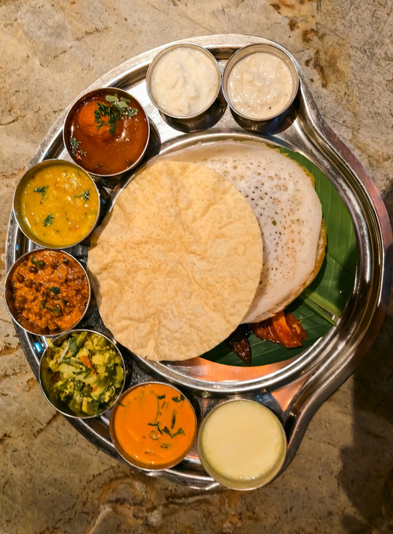 A South Indian thali with appam, papadum and curries